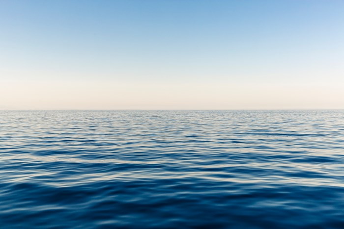 The calm, blue ocean under a clear sky