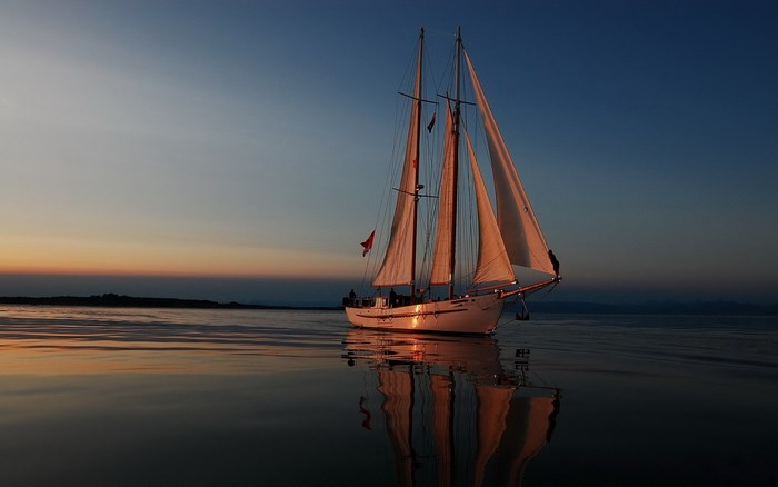 Sailboat on calm water at sunset