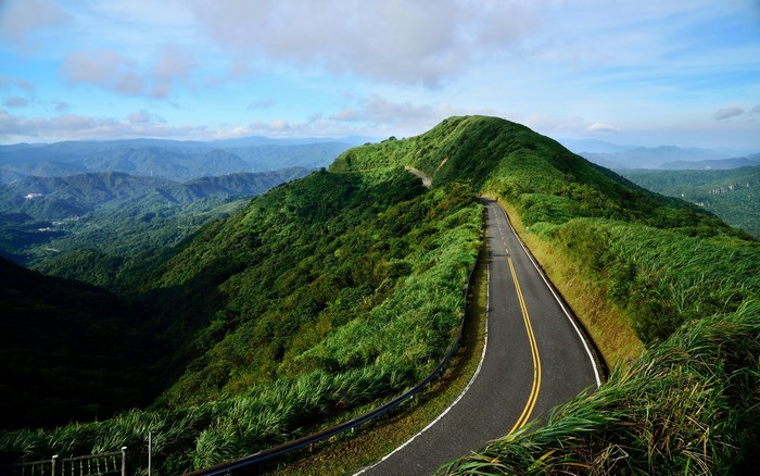 Mountain road winding through green hills