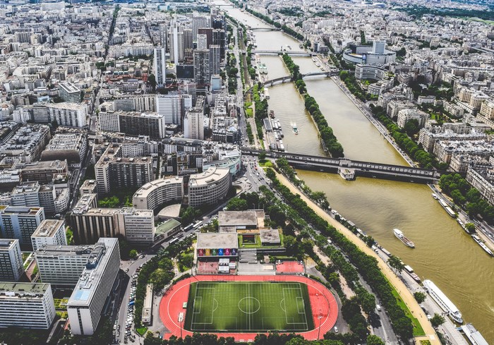 Aerial view of a city with a river and soccer stadium