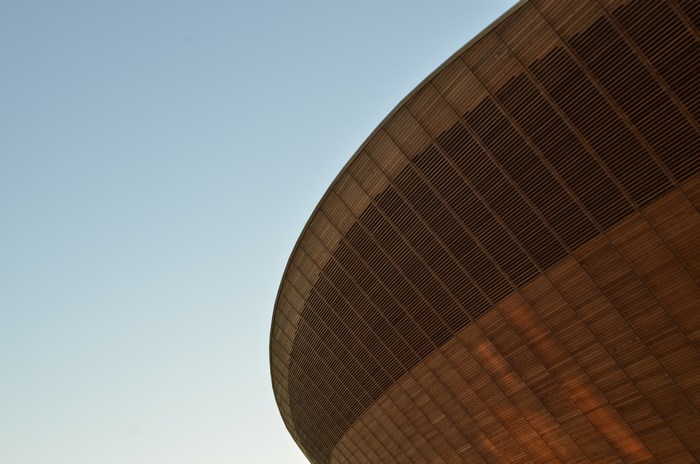Wooden structure of a velodrome against a clear sky