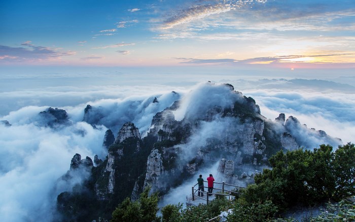 Mountain peaks shrouded in clouds at sunrise
