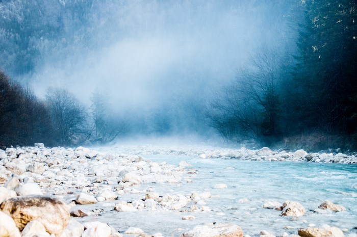 Misty river flowing through a rocky forest landscape