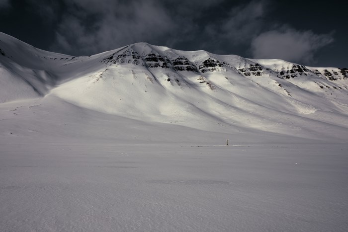Snowy mountain range in Svalbard under a dark sky
