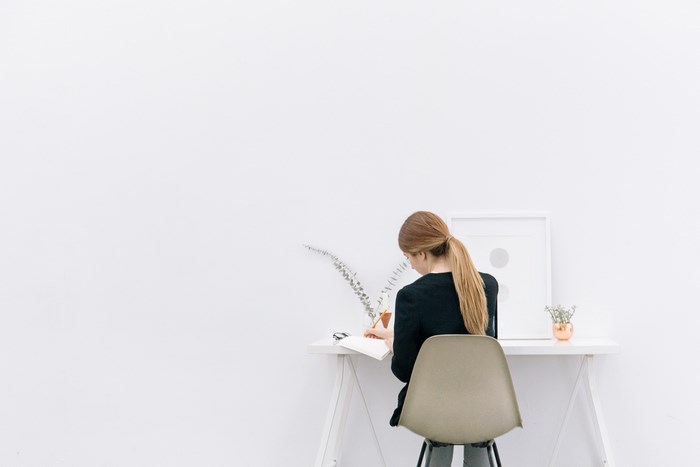 Woman writing at a minimalist desk