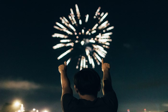 Person watching a firework explosion at night