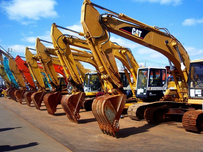 Line of Caterpillar excavators parked outdoors
