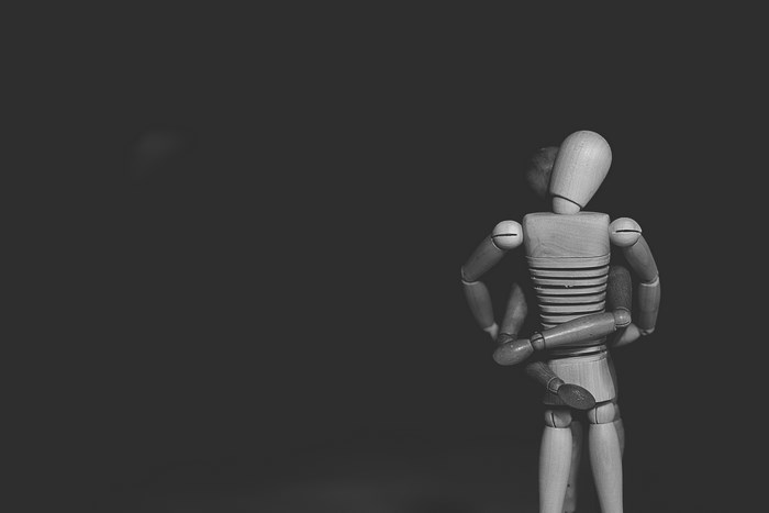 Wooden mannequins in a loving embrace