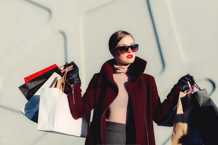 Woman in sunglasses carrying shopping bags