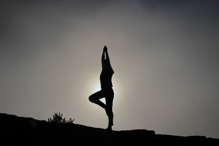 Silhouette of a person doing yoga outdoors