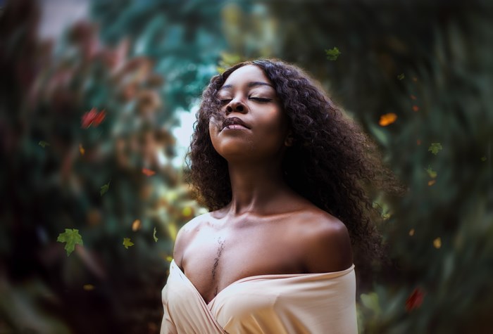 Serene Black Woman in Forest with Flowing Hair
