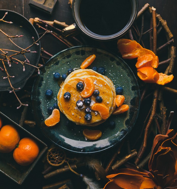Pancakes with blueberries and tangerines on a plate