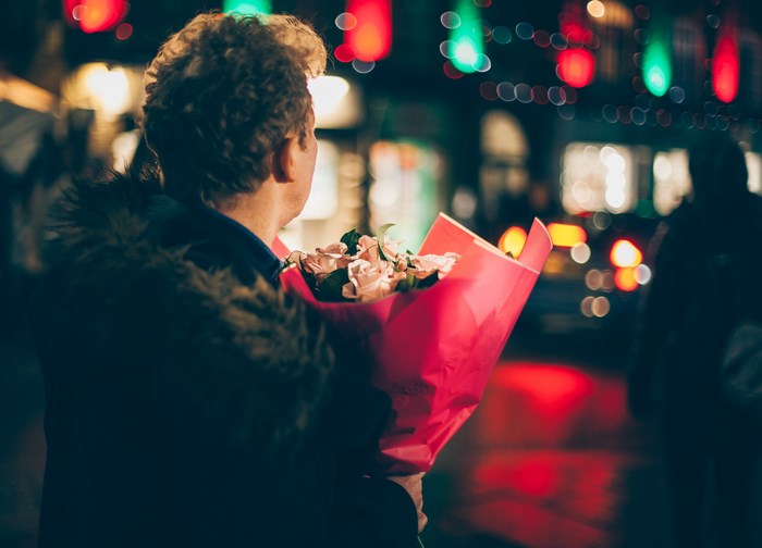 Man holding a bouquet of roses at night