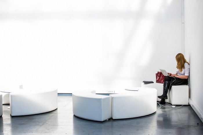 Woman working on a MacBook Pro in a modern lounge