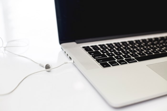Minimalist workspace with laptop and white earphones