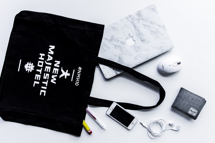 MacBook, iPhone, and Herschel wallet on a desk