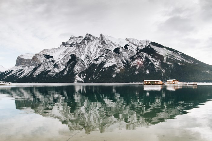 Snow-capped mountains reflected in Lake Minnewanka, Alberta