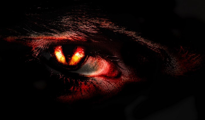 Close-up of a demonic eye with glowing red and yellow irises