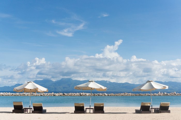 Beach with lounge chairs and umbrellas facing the sea