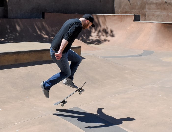 Man performing a trick on a skateboard at a skatepark