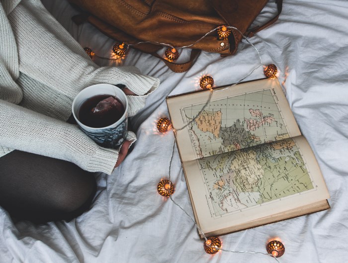 Cozy scene with tea, map, and string lights