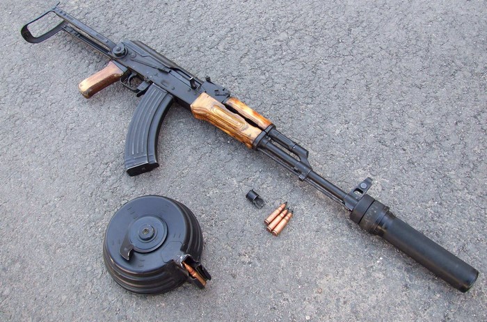 AK-47 rifle with drum magazine and suppressor