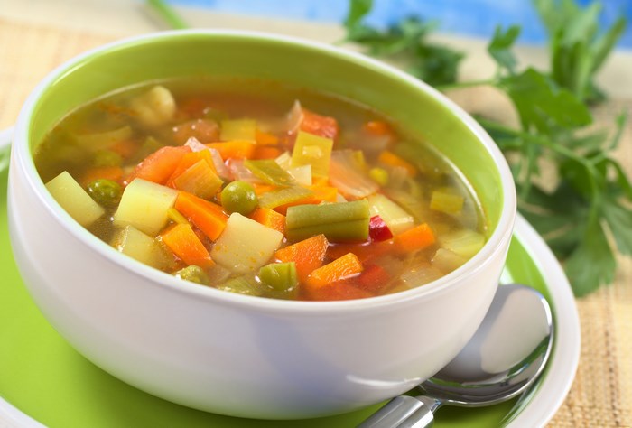 Bowl of vegetable soup with spoon
