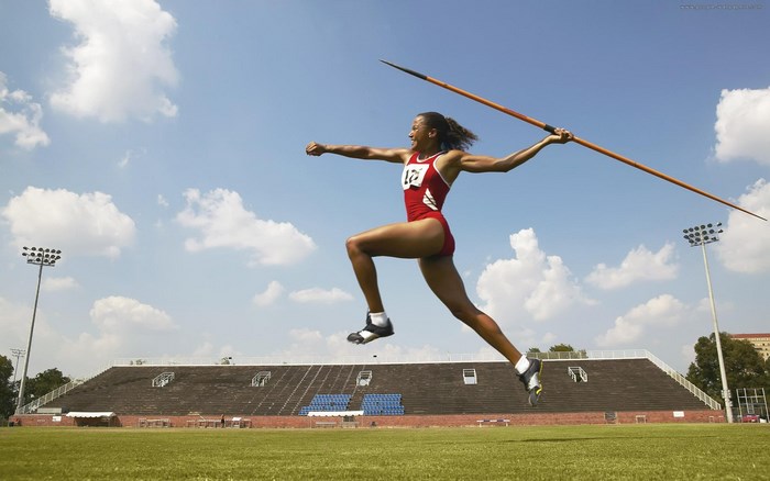 Woman throwing javelin at stadium