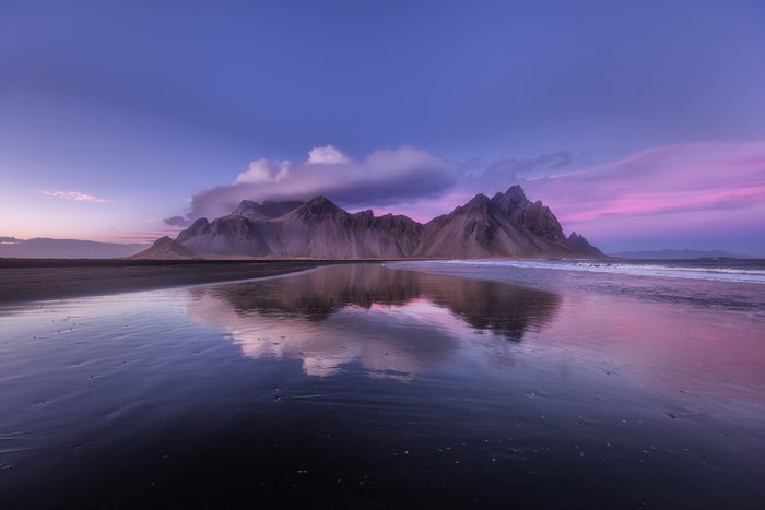 Vestrahorn mountain reflection on black sand beach in Iceland
