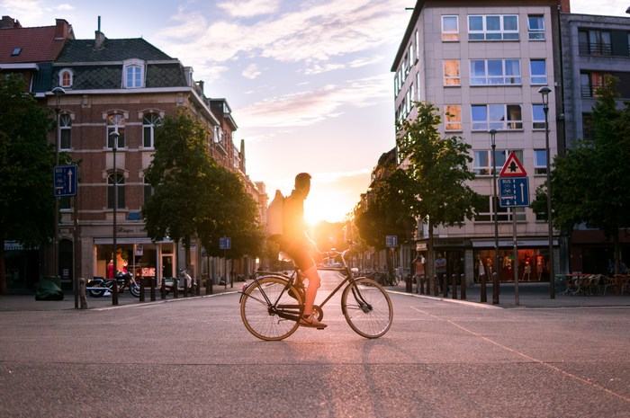 Man riding a bicycle in Leuven at sunset