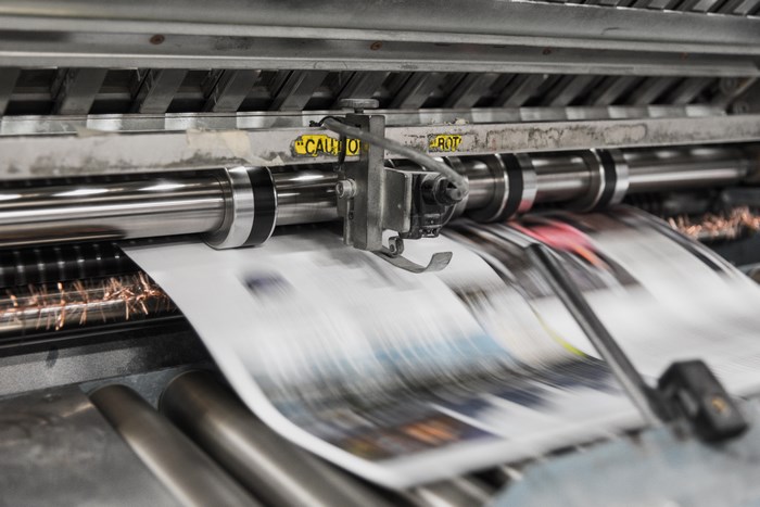 Printing machine in operation with paper