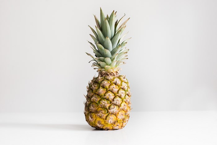 A single pineapple on a white surface