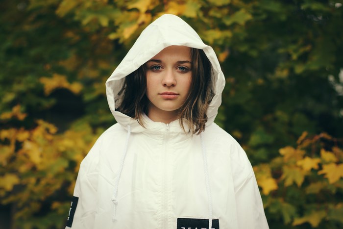 Young woman in a white hooded jacket in autumn