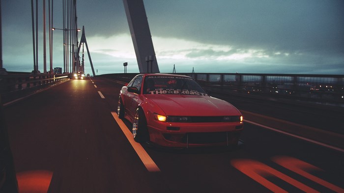 Red Nissan Silvia S14 on a bridge at dusk