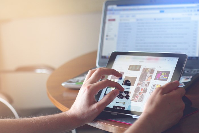 Person browsing on a tablet and laptop