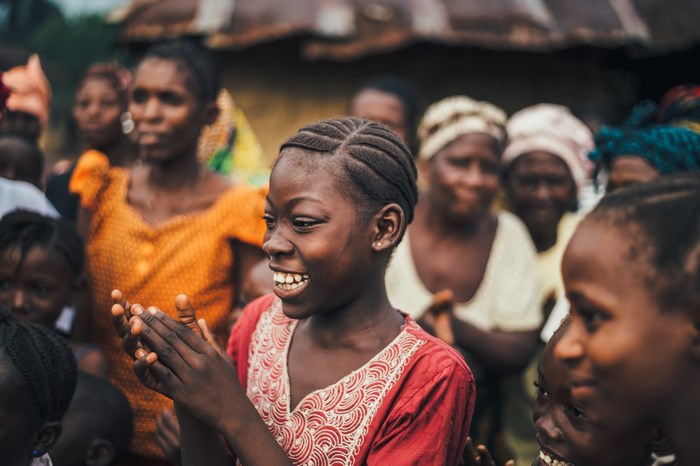 A group of Black women and girls clapping and smiling