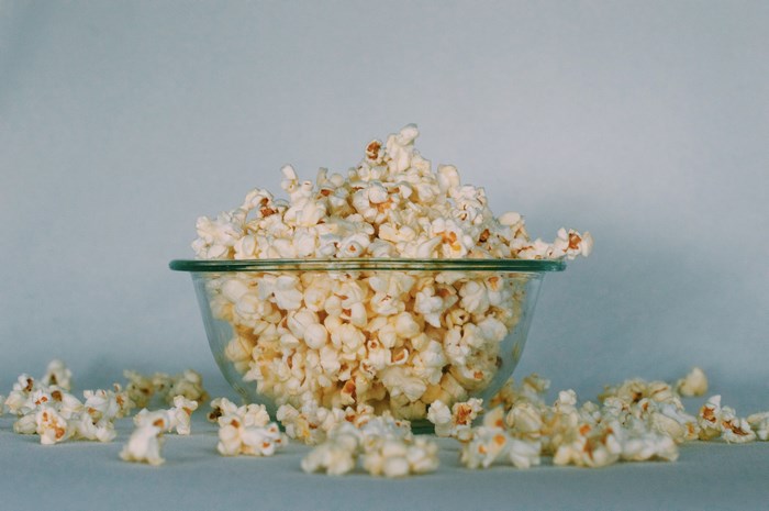 Bowl of popcorn on a light blue background