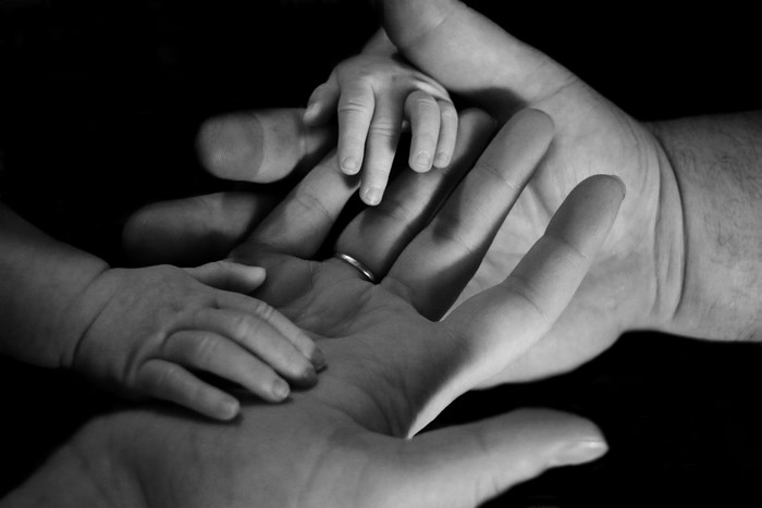 Black and White Image of Father and Baby Hands