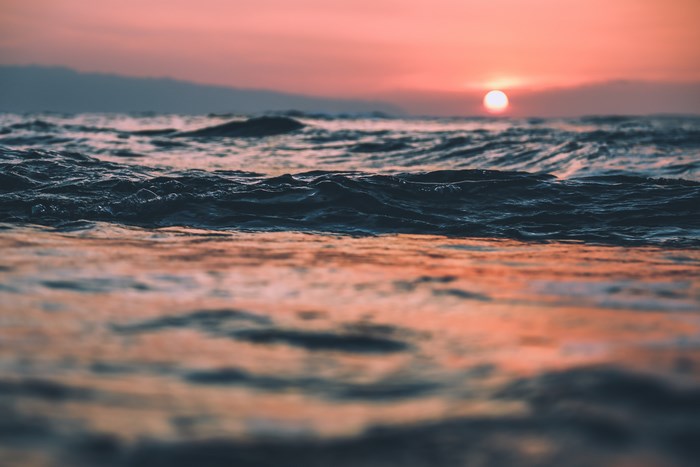 Ocean waves at sunset with a red sky