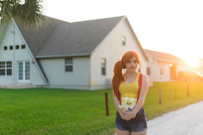 Woman in yellow tank top holding Pokemon plush