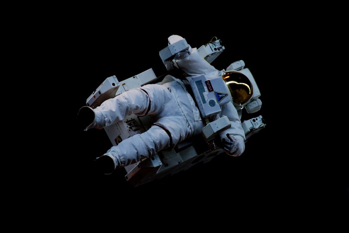 Astronaut in a white NASA suit floating in space