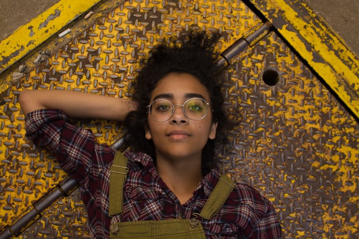 Young woman with glasses lying on metal surface