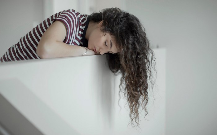 Woman with curly hair resting her head