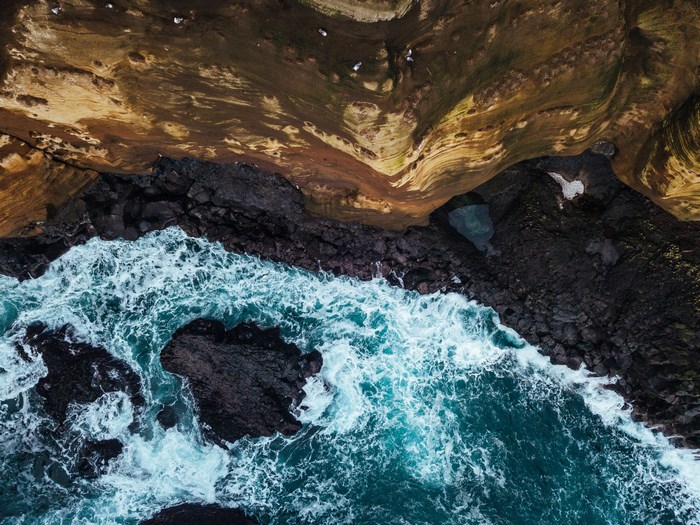 Aerial view of waves crashing on rocky coast