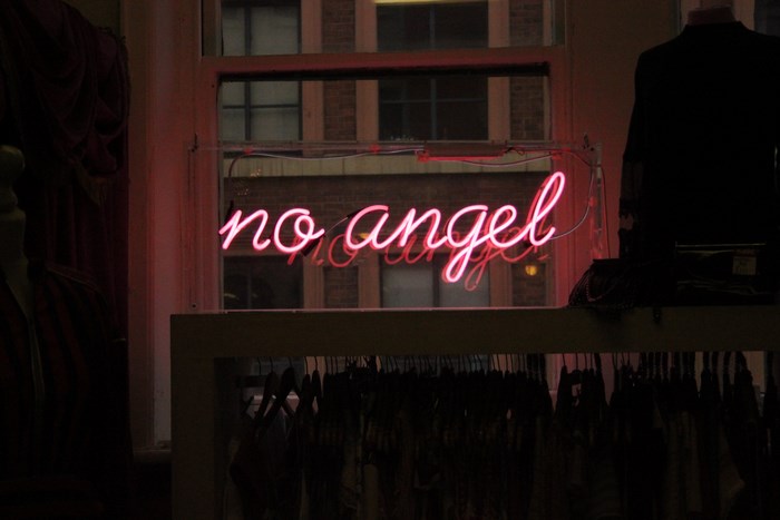 Pink neon sign 'no angel' in a window