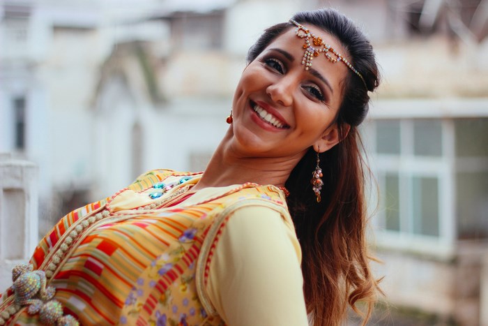 Woman in traditional dress with headdress smiling