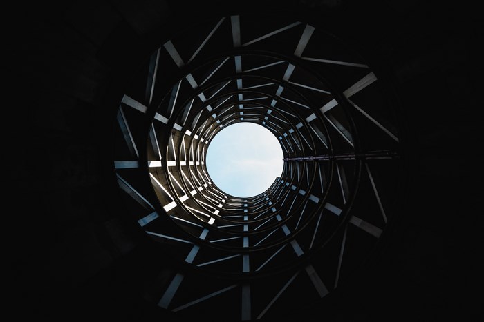 Looking up through a circular concrete structure towards the sky