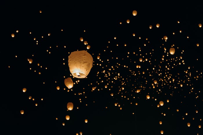 Many lanterns floating in the night sky