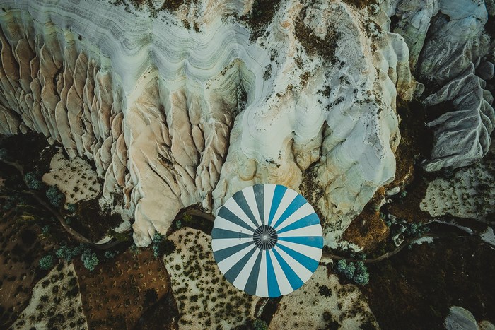 Aerial view of a hot air balloon basket over rocky terrain