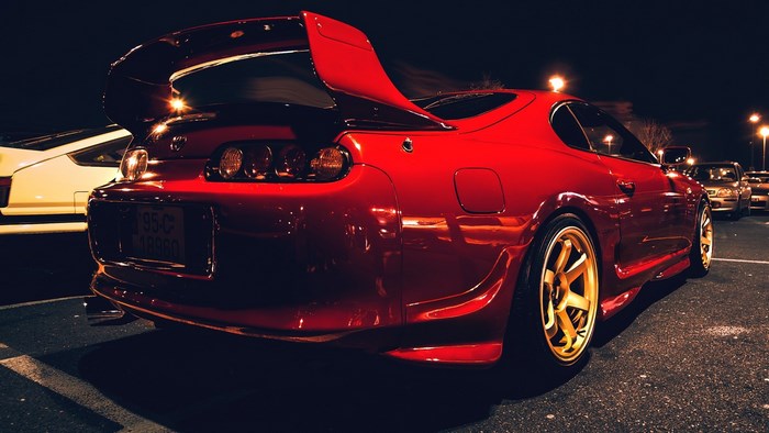 Red Toyota Supra with Gold Wheels at Night
